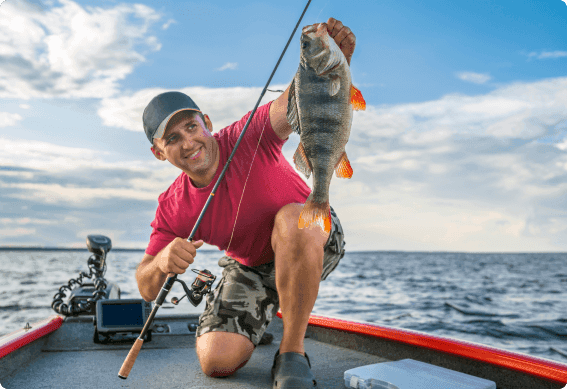 a man holding a fish on a boat