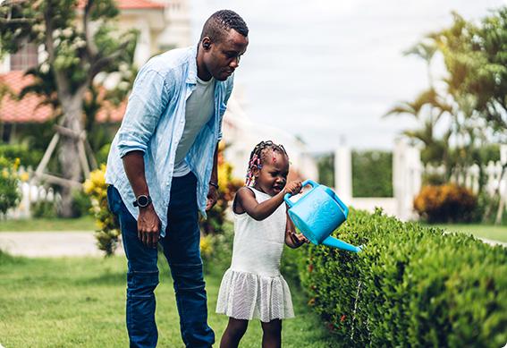 a man and a girl holding a blue bucket watering the plants