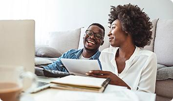 a man and a woman looking at a laptop