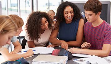 a group of people sitting at a table looking at papers