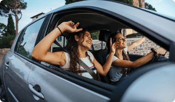 two women enjoying their drive in a car