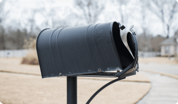 a dented mailbox after being hit by a car