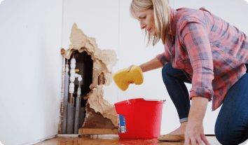 a woman cleaning up water damage on a wall