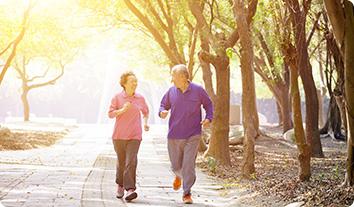 a man and a woman jogging on a path in the woods