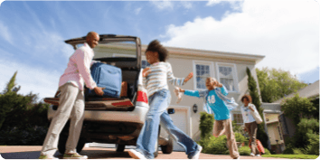 Family unloading luggage from a car