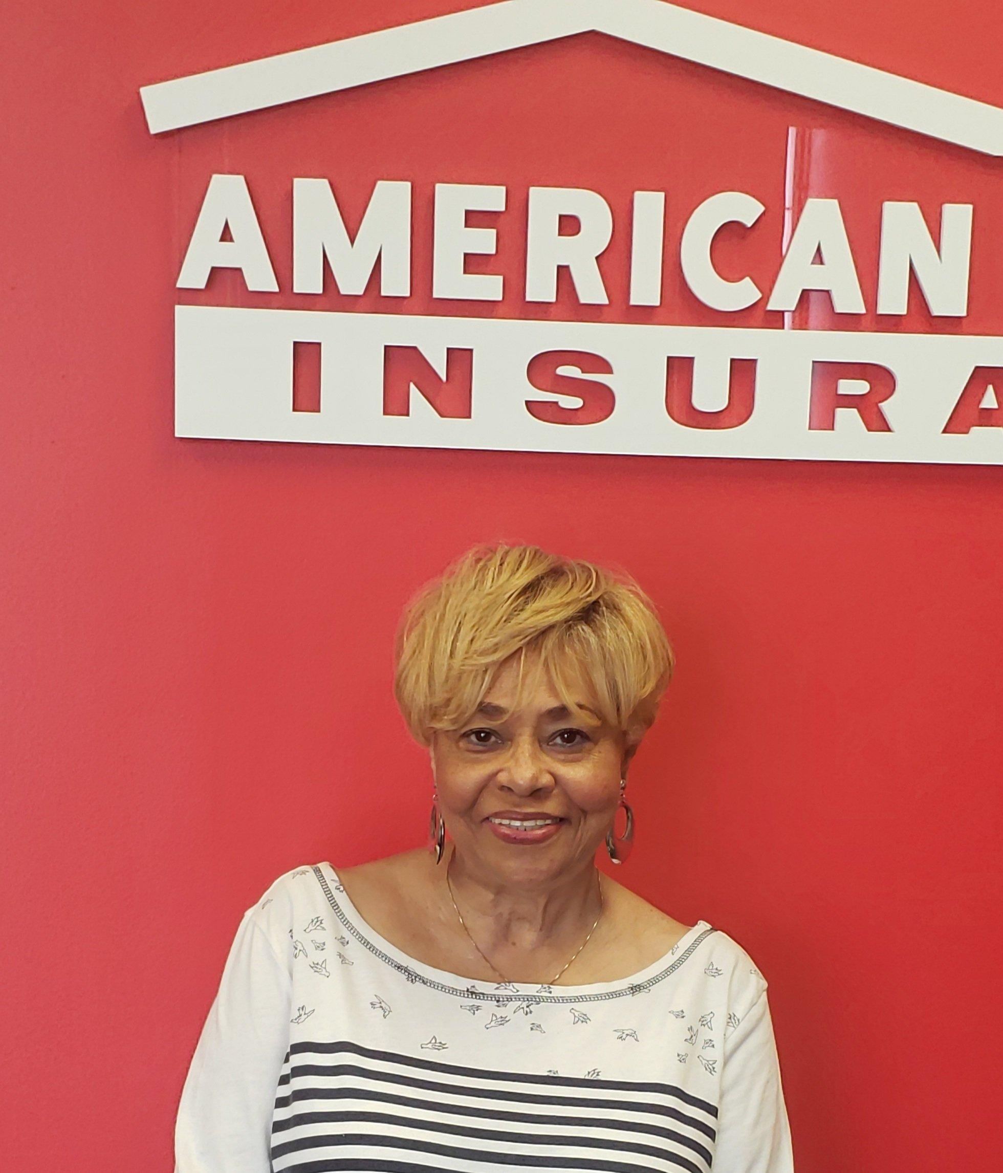 Shirley Verrett smiling in front of a sign