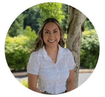 a person smiling in front of a tree