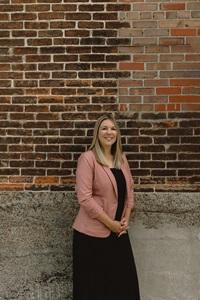 a woman standing in front of a brick wall