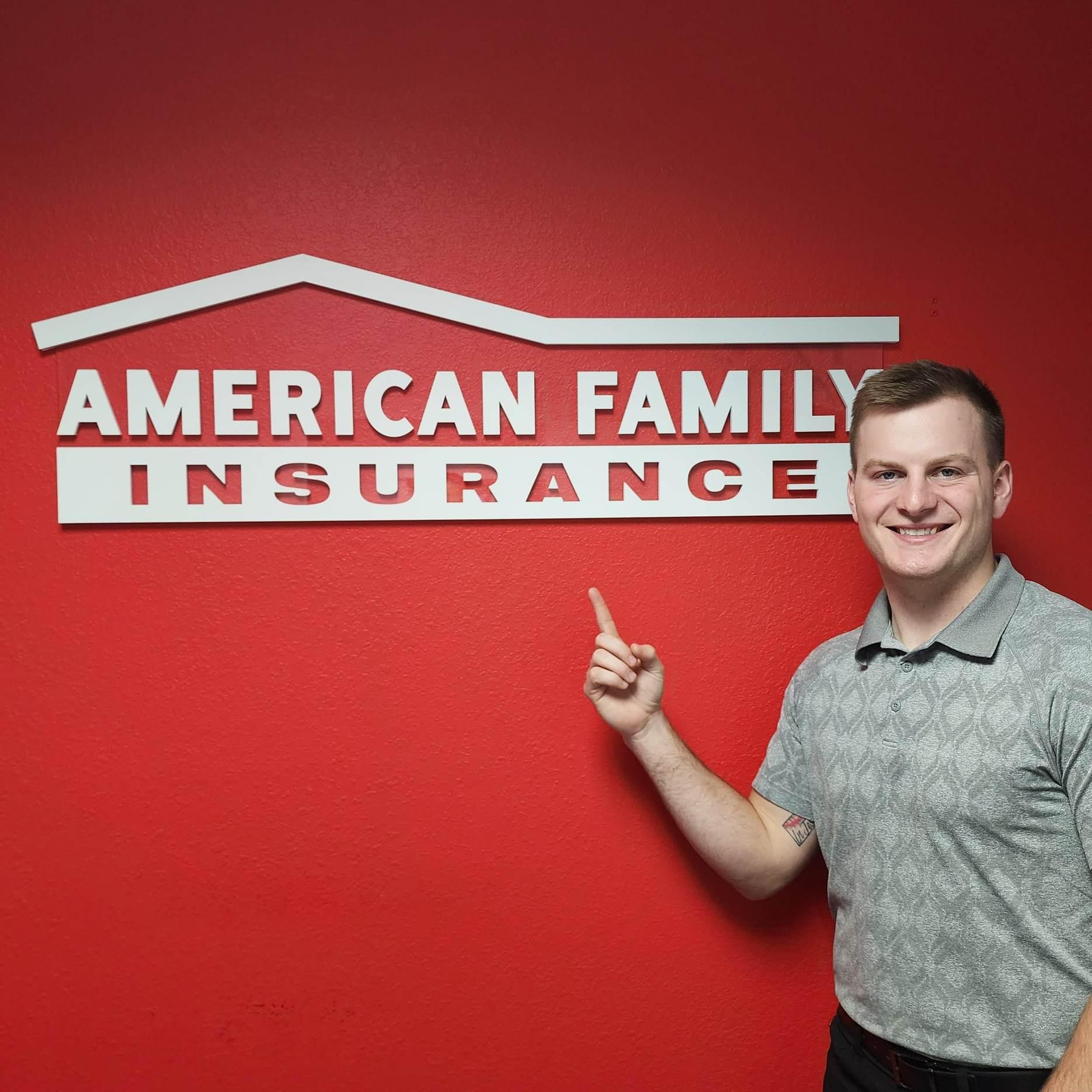 a person standing in front of a red wall with a white sign