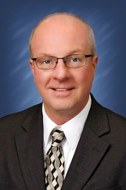 a man wearing glasses and a suit