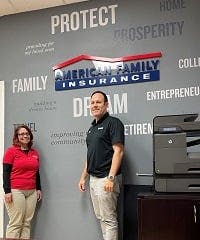 a man and a woman standing in front of a sign