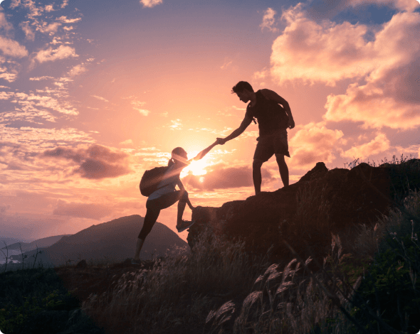 Two people climbing rocks on a hike.