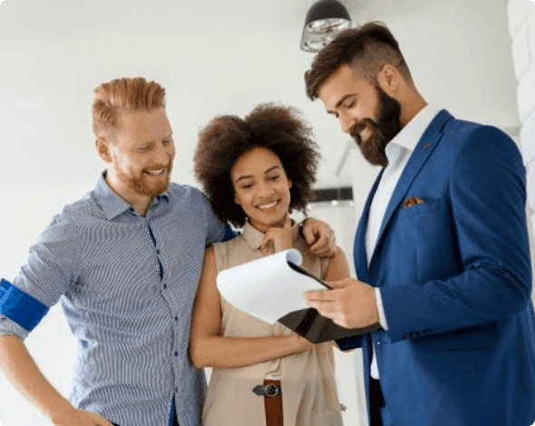 Happy couple reviewing documents for a new house with a real estate agent. 