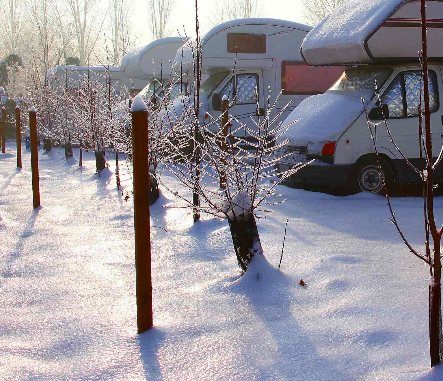 line of RVs sitting in a parking lot in snow