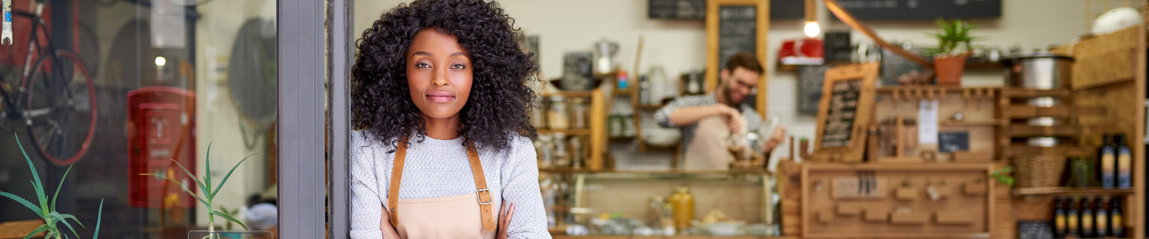 Woman standing at the entrance of her coffee shop