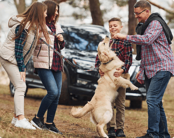 Family with dog playing in the woods.