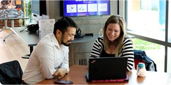 a man and a woman looking at a laptop