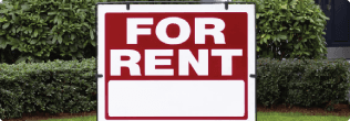 a sign with a red and white sign in front of bushes