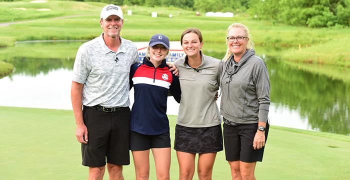 Steve Stricker et al. posing for a photo in front of a pond