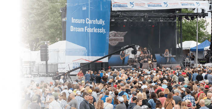 a large crowd of people watching a band on stage