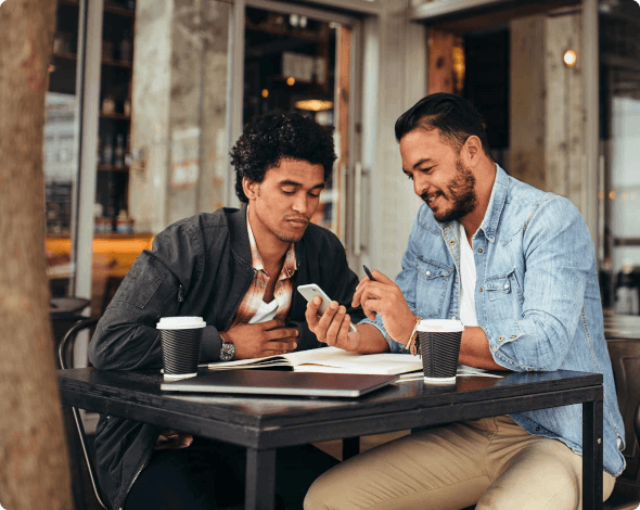 two men looking at a phone