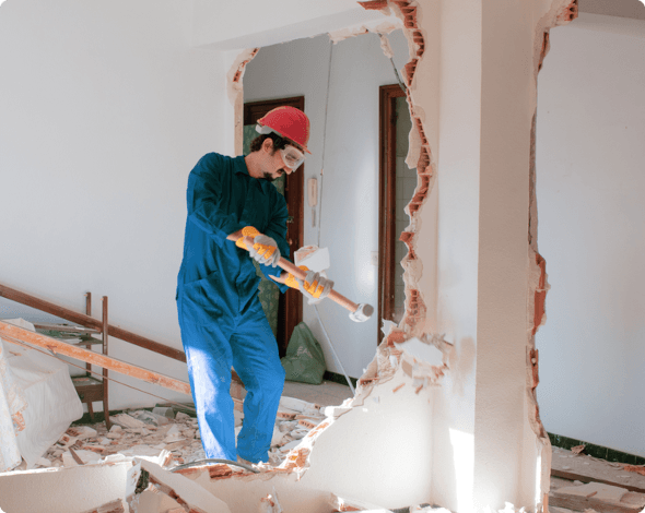 a man with a sledgehammer doing demolition on a home