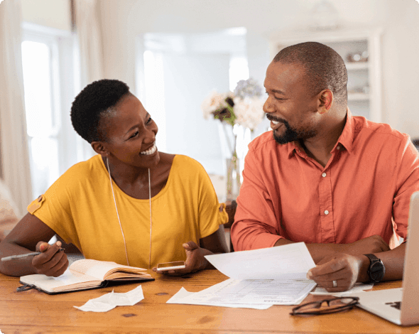 A happy couple reviewing their bills at a table.