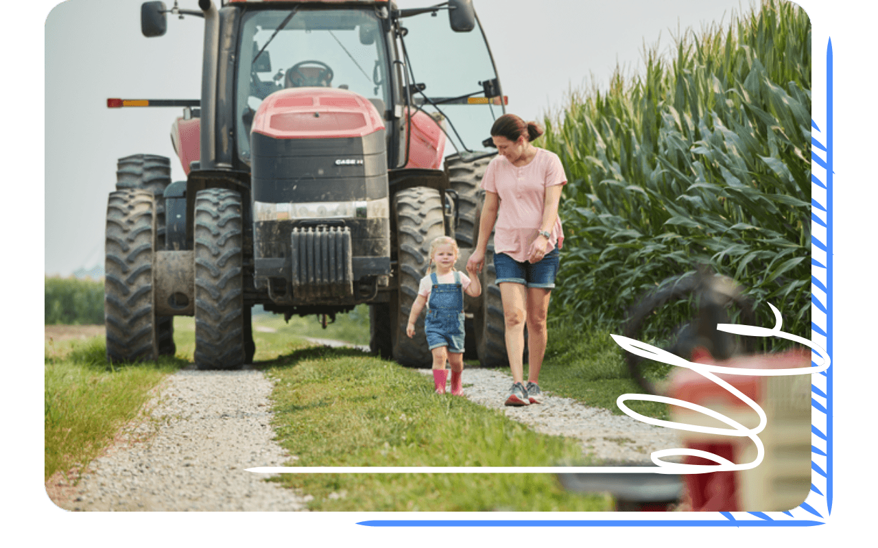 a person and a child standing next to a tractor