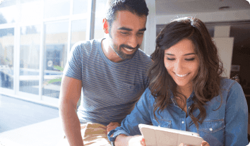 a man and a woman looking at a laptop